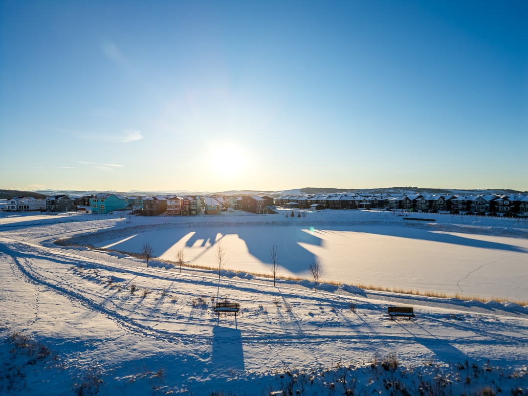 Snowy pathway winding through Pine Creek's green spaces in winter.